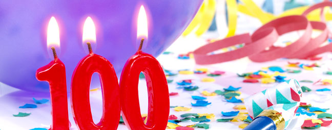 Lighted candles in shape of 100 and party decorations