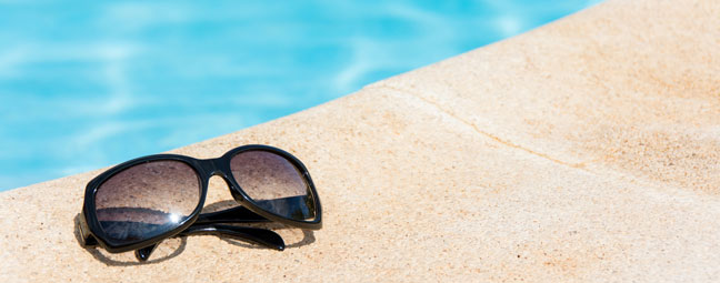 Sunglasses and pool symbolising Summer