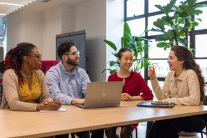 A group of smiling colleagues sitting at a table in a meeting room